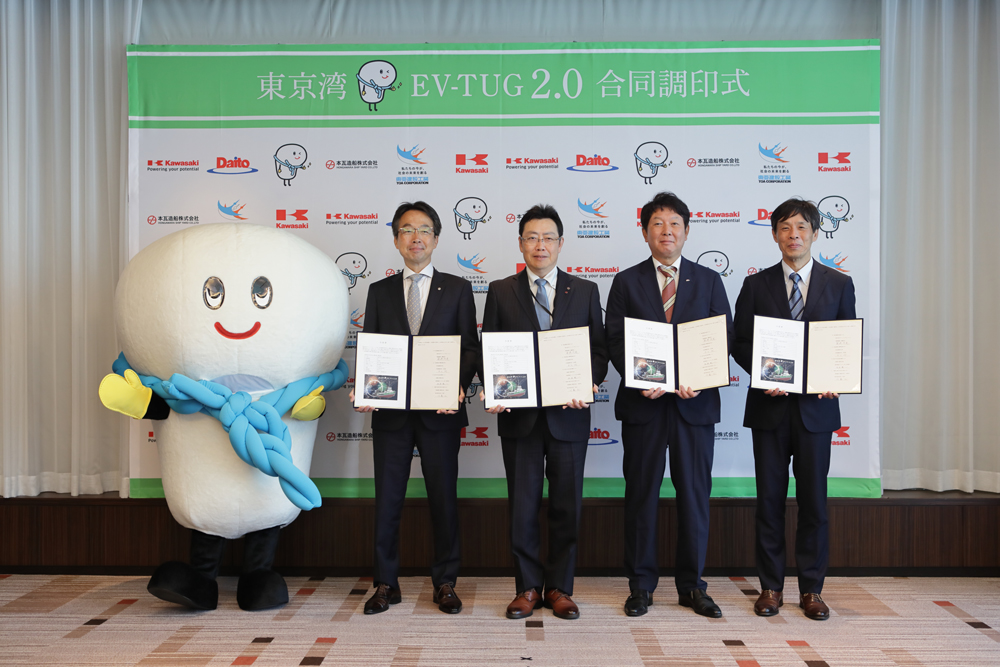 Signing ceremony
From left
- Daito Corporation’s mascot character, “Tsunagu Chan”
- TOA CORPORATION, Hitoshi Kawashima, Executive Officer General Manager of Chiba Branch
- HONGAWARA SHIP YARD CO., LTD., Makoto Hongawara, President
- Daito Corporation, Takashi Shinozaki, Senior Managing Director
- Kawasaki Heavy Industries, Ltd. ,Kenichi Masamoto, Executive General Manager of Marine Machinery Business Division