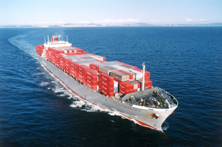 A photo of a container ship in transit on international maritime transport, taken from the air.