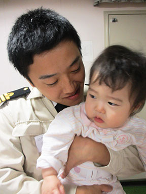 Our male maritime officer holding his baby daughter who visited the vessel.